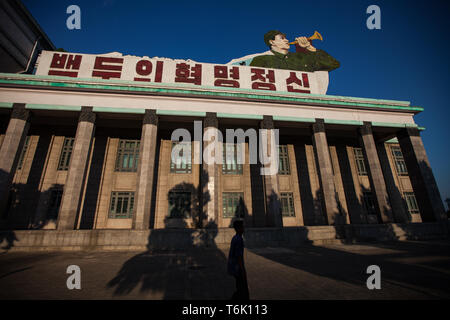 Un bâtiment à l'angle de la Place Kim Il Sung à Pyongyang a une grande image d'un clairon de messages sur le toit. Banque D'Images