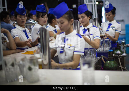 Les serveuses au festival de la bière de Pyongyang pintes servir pour les habitants et les touristes. Banque D'Images