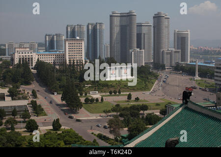 Parmi les gratte-ciel modernes à Pyongyang, grands portraits de Kim Il Sung et Kim Jong Il s'asseoir dans un parc. Banque D'Images