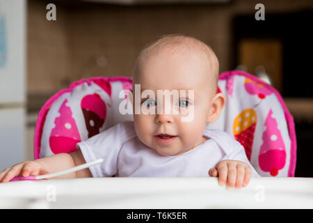 Bébé dans un siège pour enfant manger des légumes.bébé dans la chaise de bébé manger des légumes et souriant.comme premier aliment solide.enfant 8 mois Banque D'Images