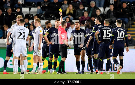 Match arbitre Peter Bankes (centre) livres Derby County's Mason Bennett (centre droit) au cours de la Sky Bet Championship match au Liberty Stadium, Swansea. Banque D'Images