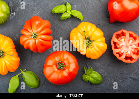 Sélection de produits bio de grandes feuilles de basilic et d'héritage bleu foncé sur fond de béton, vue du dessus, selective focus Banque D'Images