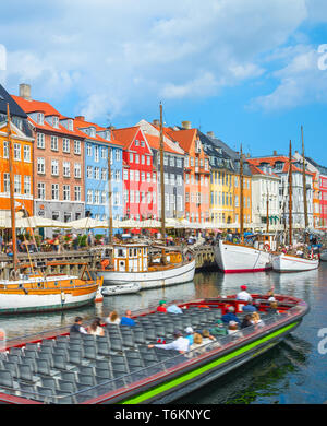 Tour de la voile par canal avec de vieux voiliers du port de Nyhavn, personnes au pied du remblai ensoleillé et assis dans les cafés et restaurants, Copenhague, D Banque D'Images