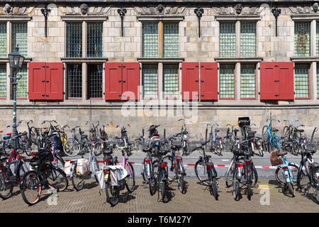 Les vélos en face d'un vieux bâtiment historique néerlandais Banque D'Images