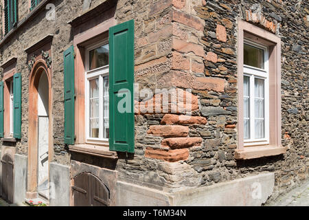 Façade d'une vieille maison en pierre avec des volets en bois Banque D'Images
