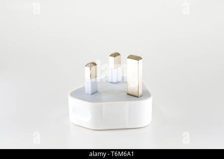 Vue rapprochée d'un adaptateur de voyage USB connecteur pour alimentation secteur pour le Royaume-Uni isolés contre un arrière-plan uni, blanc. Banque D'Images