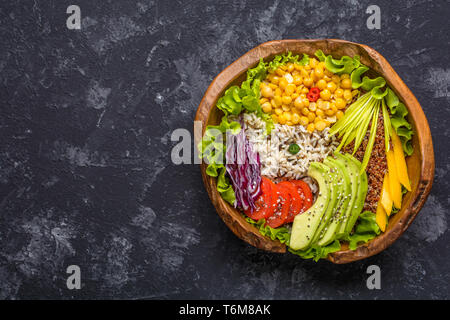 Bol Bouddha avec le pois chiche, l'avocat, le riz sauvage, le quinoa, le poivron, les tomates, les verts, le chou, la laitue sur table en pierre. Super aliments végétariens. À Banque D'Images