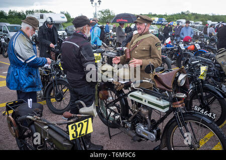 Un homme en uniforme de la Première Guerre mondiale par sa période classique moto Triumph à l'exécuter. Banbury Banque D'Images