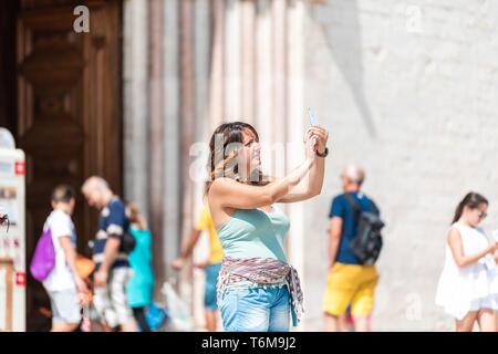 Assisi, Italie - 29 août 2018 : femme gens touristes prenant photo selfies en Ombrie ville village ville par church Banque D'Images