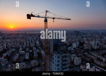 Netanya, Centre Quartier, Israël - 2 Avril 2019 : Vue aérienne d'un site de construction dans une ville au cours d'un lever de soleil coloré. Banque D'Images