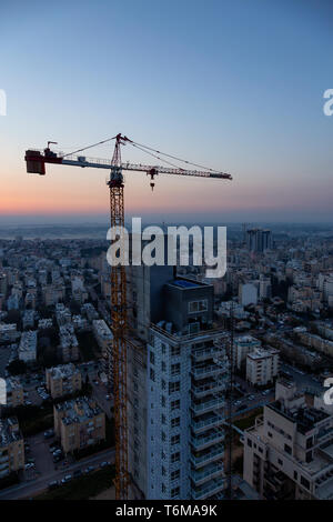 Netanya, Centre Quartier, Israël - 2 Avril 2019 : Vue aérienne d'un site de construction dans une ville au cours d'un lever de soleil coloré. Banque D'Images