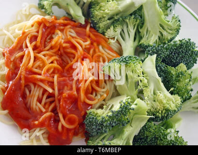 Les pâtes spaghetti avec une sauce tomate sans viande faits maison. Le brocoli frais biologiques sur le côté Banque D'Images