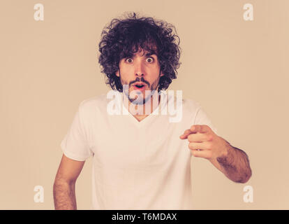 Portrait de jeune homme attrayant drôle avec heureux et surpris face à pointer et à excité à quelque chose de choquant et bon. Les émotions humaines, faci Banque D'Images