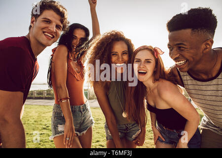 Groupe de multi-ethnic friends dancing en plein air et de rire. Les amis d'avoir un grand temps sur leurs vacances d'été. Banque D'Images