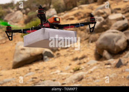 Drone quadcopter assemblé la prestation d'un package avec moutain en arrière-plan Banque D'Images