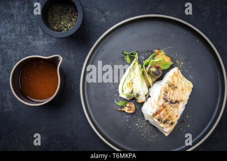 Thaï moderne morue frite filet de poisson avec le bok choi et champignons comme vue de dessus sur une plaque Banque D'Images