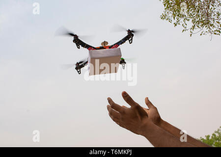 Drone quadcopter assemblés livrer un colis et recevoir le colis des mains Banque D'Images