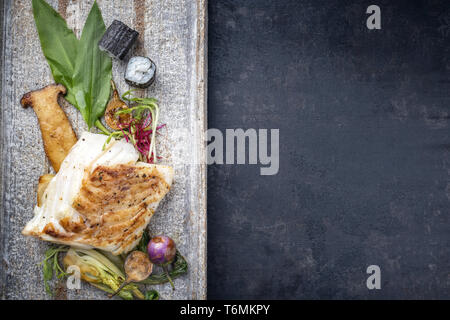 Morue frite japonaise moderne avec des filets de poisson bok choi et rouleaux de sushi en vue de dessus sur une plaque avec copie espace droit Banque D'Images