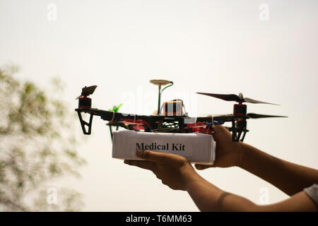 Concept de drone quadcopter assemblé la prestation d'un kit médical d'urgence et recevoir des mains trousse médicale. Banque D'Images