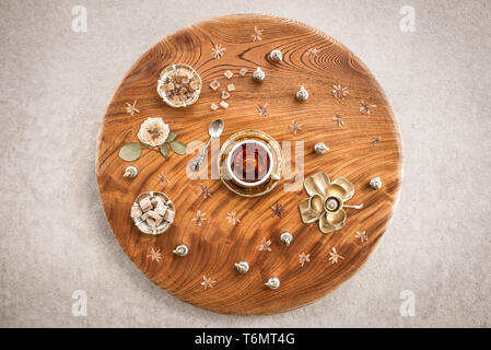 Du thé et du sucre sur une table ronde en bois décoré de fleurs séchées. Banque D'Images