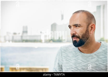 Portrait d'un homme espagnol avec barbe et cheveux court buzz, à l'écart, occasionnels, pensive, rêver, le profil Voir plus de contexte urbain. Banque D'Images
