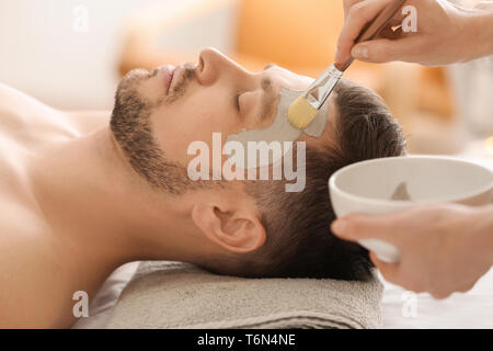 L'application de masque cosmétique Cosmetologist sur le visage de l'homme de spa salon Banque D'Images