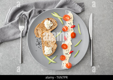 Pain grillé servi avec du fromage à la crème et du beurre sur la plaque, vue du dessus Banque D'Images