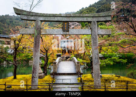 Temple Eikando arche en pierre et pont de jardin à Kyoto, au Japon, au début du printemps avec la mousse jaune et vert des arbres Banque D'Images