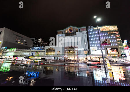 Shinjuku, le Japon - 1 Avril 2019 : grand centre commercial extérieur en centre-ville de ville avec un éclairage au néon signe la nuit pendant la pluie avec reflet de Banque D'Images