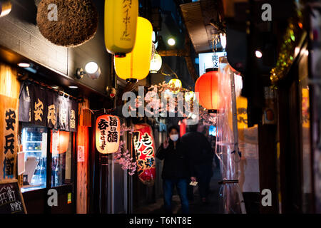 Tokyo, Japon - 3 Avril, 2019 : Memory Lane alley avec des décorations et des lampes et lanternes de papier jaune personnes dans le quartier de Shinjuku de ville la nuit Banque D'Images