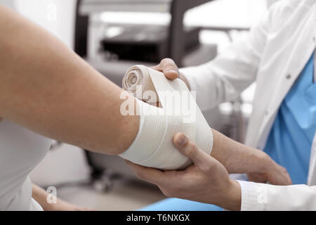 Orthopédiste bander bras du patient à l'hôpital Banque D'Images