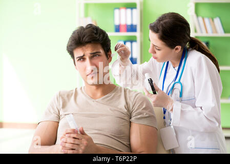 Femme médecin contrôle de l'oreille du patient pendant l'examen médical Banque D'Images