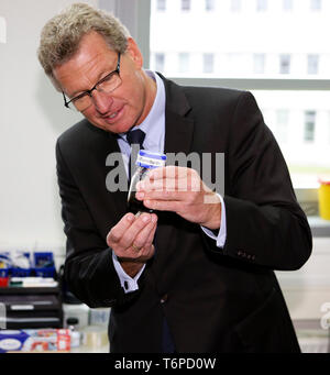 02 mai 2019, le Schleswig-Holstein, Lübeck : Bernd Buchholz (r, FDP), de l'économie Ministre du Schleswig-Holstein, est titulaire d'un verre rempli de liquide magnétique dans ses mains. Le jeudi, l'homme politique a présenté l'Université de Lübeck avec une décision de financement pour près de 540000 euros. L'argent est destiné à l'établissement d'un laboratoire à l'Institut de robotique et systèmes cognitifs et de la technologie médicale. Photo : Frank Molter/dpa Banque D'Images