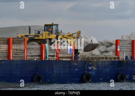 West Bay, Dorset, UK. 2e mai 2019. Une grande défense côtière est en cours à West Bay, dans le Dorset. De gros blocs sont livrés par bateaux et off chargé dans le front de mer par des charges de godet. Les pierres proviennent d'Écosse où sa reprise par de grandes attaches mécaniques et fait monter la plage de galets. Le front de mer est l'endroit où l'émission de télévision Broadchurch a été filmé.Photo Credit : Robert Timoney/Alamy Vivre Newss Banque D'Images