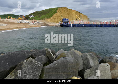 West Bay, Dorset, UK. 2e mai 2019. Une grande défense côtière est en cours à West Bay, dans le Dorset. De gros blocs sont livrés par bateaux et off chargé dans le front de mer par des charges de godet. Les pierres proviennent d'Écosse où sa reprise par de grandes attaches mécaniques et fait monter la plage de galets. Le front de mer est l'endroit où l'émission de télévision Broadchurch a été filmé.Photo Credit : Robert Timoney/Alamy Vivre Newss Banque D'Images