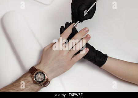 L'homme sur les procédures dans le salon de manucure. Spa, manucure, traitement des ongles du poussoir. Beau mâle mains. Banque D'Images