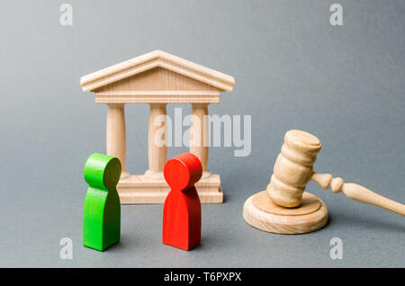 Figures en bois de gens debout près du marteau du juge. Litiges. Les rivaux. Conflit d'intérêts. Le droit et la justice. La couche de services. Tw Banque D'Images