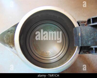 Calcaire dans une bouilloire sur la surface grise. Dirtykettle sur le fond gris. Banque D'Images