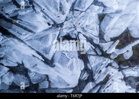 Réseau de fissures dans la couche gelée épaisse de glace avec lumière Banque D'Images