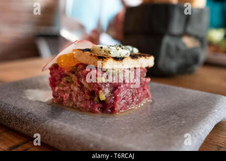 Steak tartare avec du jaune crémeux et brioche grillée avec du beurre de sauge Banque D'Images