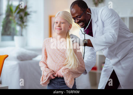 Girl smiling lors d'une visite à l'aide d'un pédiatre stethoscope Banque D'Images