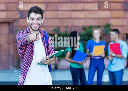 Beau mâle espagnol étudiant avec groupe d'étudiants en plein air de l'été dans la ville Banque D'Images