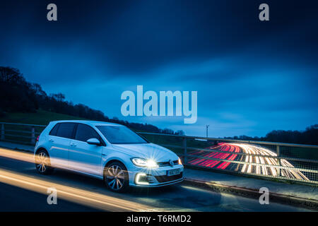 Volkswagen Golf GTE sur un pont surplombant la M25 la nuit Banque D'Images