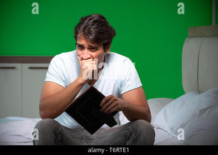 Beau jeune homme souffrant d'amour dans la chambre à coucher Banque D'Images