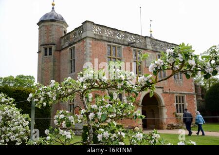 Gatehouse de Charlecote maison avec l'espalier des pommes en fleurs en premier plan, Warwickshire, England, UK Banque D'Images