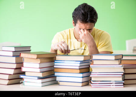 Étudiant avec trop de livres à lire avant l'examen Banque D'Images