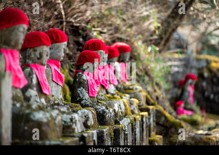 Statues Jizo rouge célèbre dans Kanmangafuchi Abyss, Nikko, Tochigi au Japon avec des chapeaux, de nombreux chiffres protégeant les morts Banque D'Images