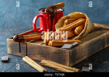 Churros avec du chocolat chaud. Banque D'Images