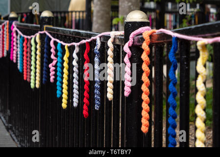 Brins de laine de couleur affichée (attentat à la laine) sur clôture à Wilton Village Shopping, Wilton, Salisbury, Wiltshire, Royaume-Uni Banque D'Images