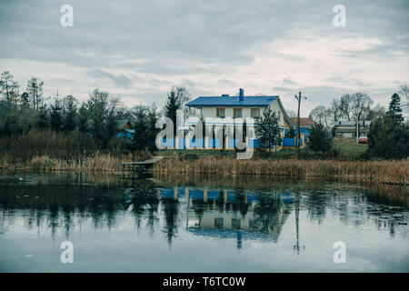 Vue de la maison avec un toit bleu près de l'étang Banque D'Images